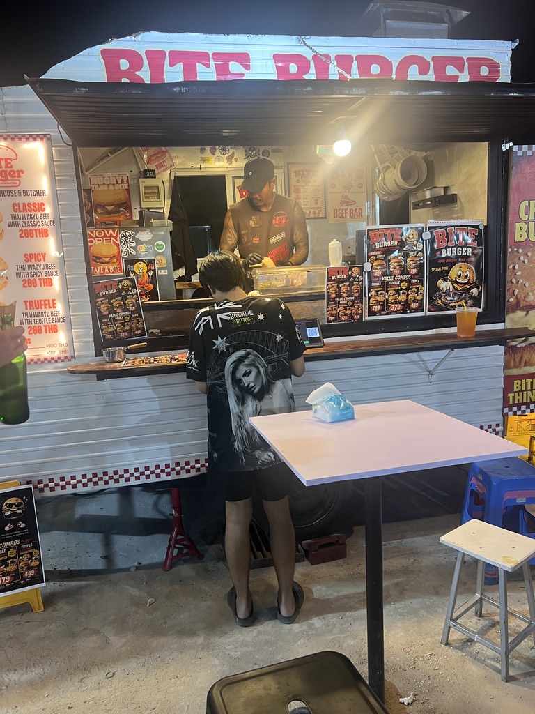 Thai street food stall serving a customer — eating together in Thailand